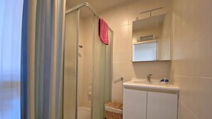 A bathroom with a glass-enclosed shower, a white sink, and a mirror above it. - 2 bedroom accommodation in Nieuwpoort (Nieuwpoort)