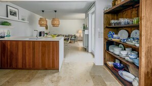 A modern kitchen with wooden cabinetry, a central island, and a dining area with a sofa and table. - 4 bedroom accommodation in Oostduinkerke (Oostduinkerke)