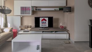 A modern living room with a TV, sofa, coffee table, and a bookshelf. - 2 bedroom accommodation in Nieuwpoort (Nieuwpoort)