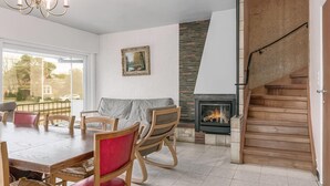 A dining area with a wooden table and chairs, a fireplace, and a staircase. - 5 bedroom accommodation in Koksijde (Koksijde)