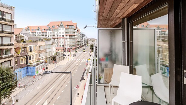 A balcony with a view of a city street, a wooden ceiling, and a glass door. - 2 bedroom accommodation in Oostduinkerke (Oostduinkerke)