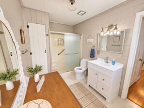 Un bagno con un mobile lavabo bianco, un water e uno spazio doccia.