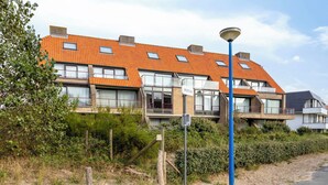 A row of modern residential buildings with orange tiled roofs, large windows, and a street lamp in the foreground. - ZeeZonZand A-GV01 + P* (Koksijde)