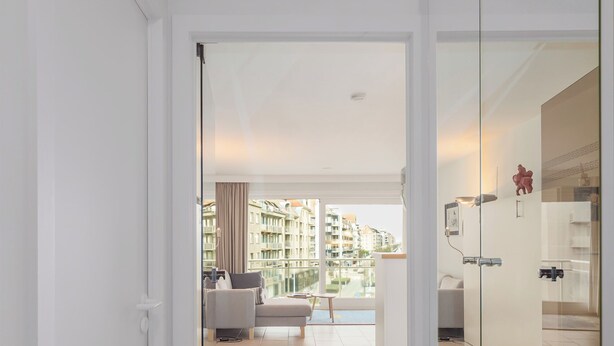 Un apartamento moderno con balcón, sofá y zona de comedor.