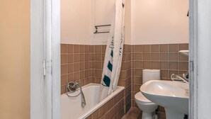 Un baño con bañera, inodoro y lavabo.