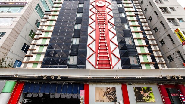 A multi-story hotel with a distinctive red and black facade, featuring a central staircase and multiple balconies. - CLIO MOTEL (Incheon)