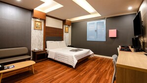 A hotel room with a bed, a desk, a chair, a sofa, and a TV. - CLIO MOTEL (Incheon)