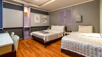 A hotel room with two beds, a desk, and a chair.