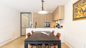 Una cocina moderna con armarios de madera, una isla central y una mesa de comedor con sillas.