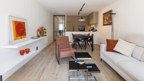 Una sala de estar moderna con sofá, mesa de centro y comedor con sillas y una mesa.