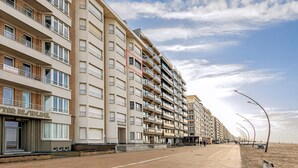 A multi-story hotel with balconies, a beachside location, and a clear sky. - 2 bedroom accommodation in De Panne (De Panne)