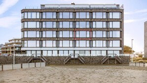 A multi-story building with a modern architectural design, featuring a series of windows and a central staircase. - 1 bedroom accommodation in Sint Idesbald (Sint Idesbald)