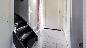 Ein Flur mit Treppe, einer Tür und einer Deckenleuchte.