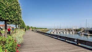 Ein hölzerner Steg mit einem Yachthafen im Hintergrund.
