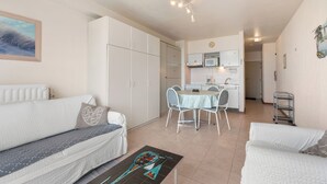 Eine moderne Wohnung mit Wohnzimmer, Essbereich, Küchenzeile und Schlafzimmer.