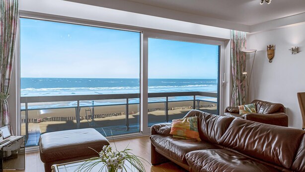 A spacious living room with a large window overlooking a beach. - 2 bedroom accommodation in Sint Idesbald (Sint Idesbald)