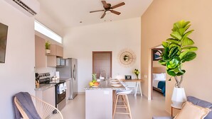 Een modern appartement met keuken, eethoek en woonkamer.