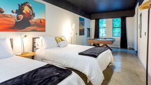 Ein modernes Hotelzimmer mit zwei Betten, einem Schreibtisch und einem großen Gemälde an der Wand.
