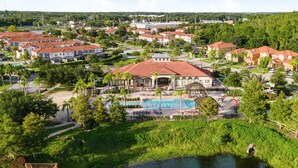 Un complejo turístico con varias edificaciones, una piscina y un lago.