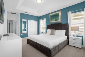Ein Schlafzimmer mit einem großen Bett, Nachttischen, einer Kommode und einem Bild an der Wand.