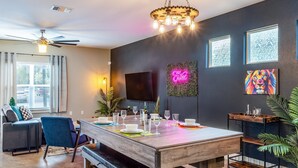 A dining area with a wooden table, chairs, and a ceiling fan. - Upstay - East Austin Home w Yard Games Fire Pit (Austin)