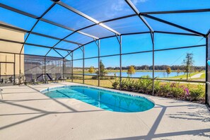 Une piscine extérieure couverte offrant une vue sur un terrain de golf et un lac.