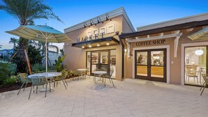 Un espace extérieur aménagé en terrasse, avec des tables et des chaises, un café et un marché.