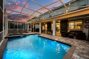 A swimming pool with a glass ceiling, outdoor seating, and a patio area. - Pool Hot Tub Resort Waterslides - Sleeps 16 (Davenport)