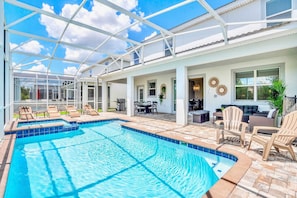 A swimming pool with lounge chairs and a covered patio area. - Pool Hot Tub Resort Waterslides - Sleeps 16 (Davenport)