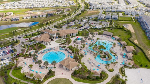 Vista aérea de un resort con varias piscinas, un pabellón central y una zona de playa.
