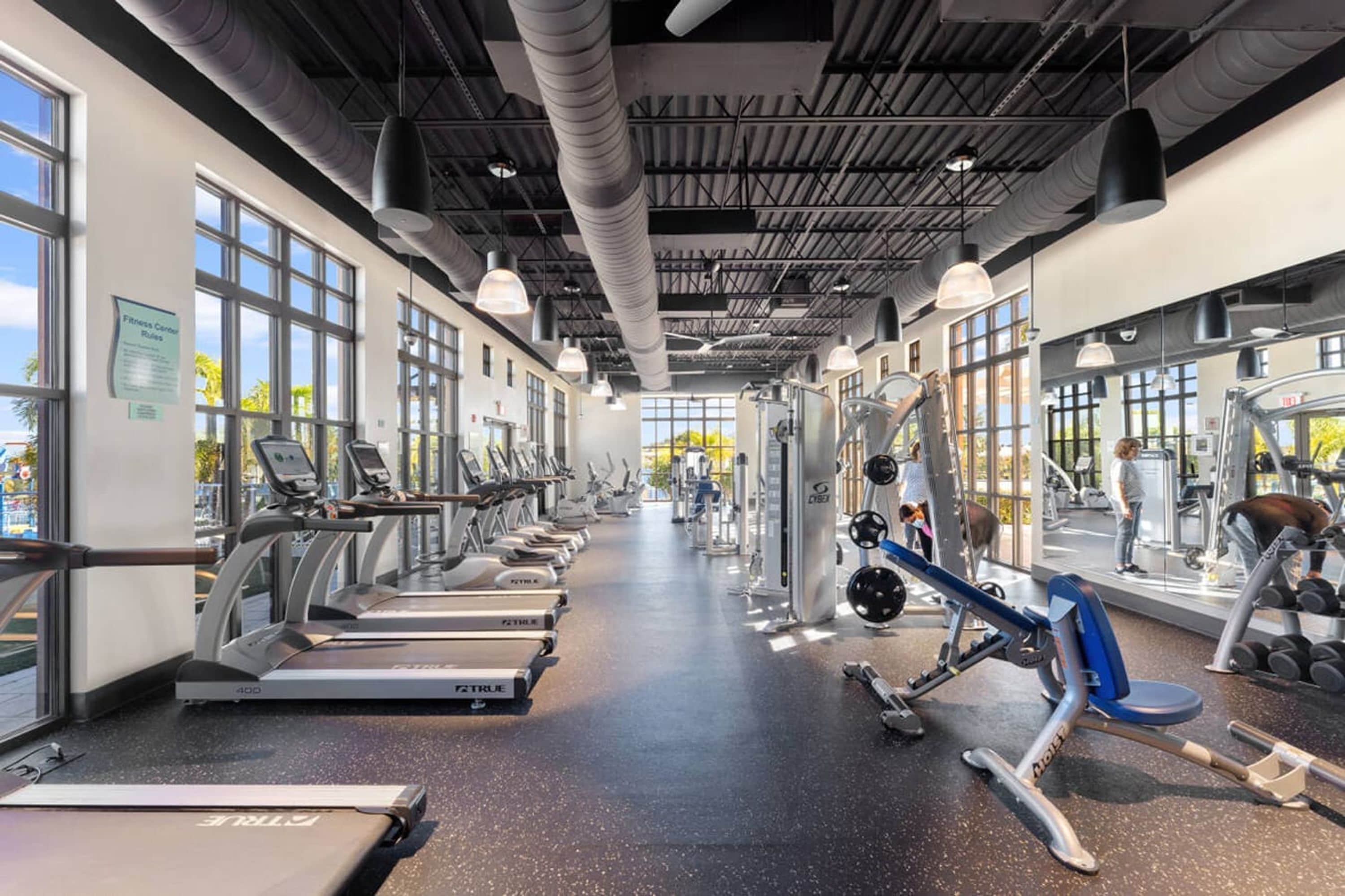 A gym with treadmills, weight machines, and free weights.