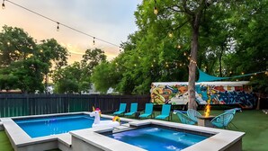 A swimming pool with a unicorn float, surrounded by chairs and a tiki torch. - Pool Hottub Magic School Bus 5 Mins to Downtown (Austin)