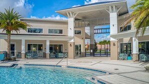 A hotel with a swimming pool, covered patio, and palm trees. - Upstay - Gator Getaway w Pool Hot Tub Theme Rooms (Kissimmee)