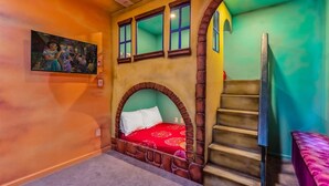 A room with a bed in an arched alcove, a staircase, and a mural on the wall. - Upstay - Gator Getaway w Pool Hot Tub Theme Rooms (Kissimmee)