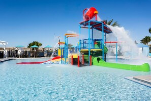 A water park with a pool, slides, and water features. - Spacious 8BR Home for Large Group - Pool Games (Kissimmee)