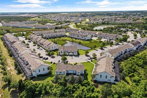 An aerial view of a residential area with a central courtyard, surrounded by houses with pitched roofs and a large building in the middle. - Upstay - Welcoming Wonderland w Private Pool (Davenport)