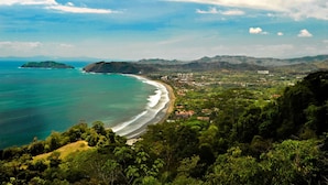A coastal town with a beach, surrounded by hills and greenery. - Upstay - NEW Build - Viva Jaco Condo w Epic Views (Jacó)