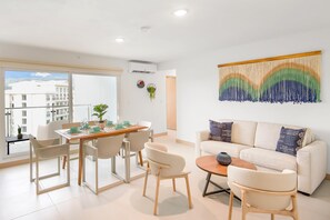 Relax in this stylish living room with a dining area, sofa, and city views.