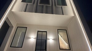 A multi-story building with a symmetrical facade, large windows, and a central staircase.