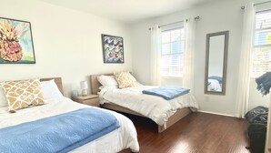 A hotel room with two beds, wooden flooring, a large mirror, and artwork on the walls. - Direct waterfront home on the Gulf of Mexico. Dunedin.  (Dunedin)
