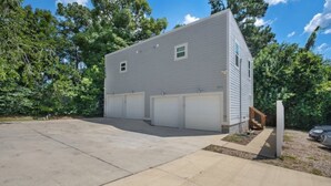 Ein zweistöckiges Haus mit Garage, Auffahrt und einem kleinen Garten.