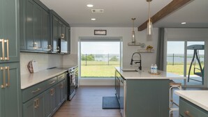 A modern kitchen with a large island, built-in appliances, and a view to the outdoors. - Spacious Modern Home with Lake view in Dallas, great amenities/full Kitchen/Wifi (Garland)