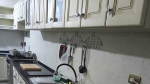 A kitchen with white cabinets, a black countertop, and a stainless steel sink. - Hermosa casa cómoda, espaciosa y con todas las comodidades  (Cochabamba)