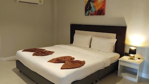 A neatly made bed with white linens and brown towels arranged on the bed. - PS Hotel Saraburi (Phra Phutthabat)