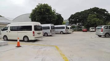 Un parking où plusieurs fourgonnettes blanches sont stationnées en rangées.