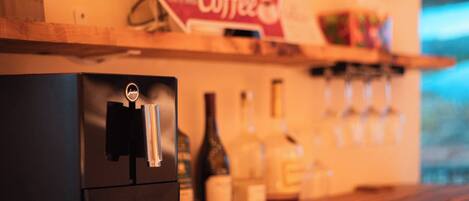 A coffee machine on a wooden counter with a sign reading "Coffee" above it.