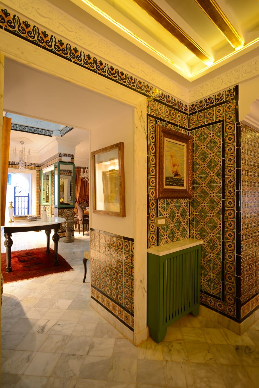 A room with patterned tile walls, a green radiator, and a framed picture on the wall.