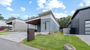 Un bâtiment moderne doté d’une allée couverte et d’une pelouse bien entretenue.