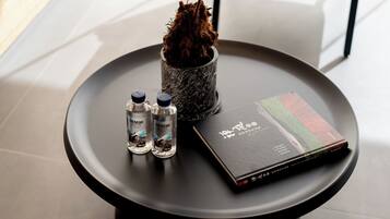 A round table with a book, two bottles, and a decorative item.