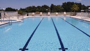 A clear swimming pool with lane dividers, surrounded by a fence and equipped with multiple entry points. - Golfing, swimming and a friendly secure community (55+) - SEASONAL (30days+) (North Fort Myers)